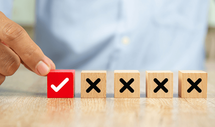 A male hand selects one wooden block from a choice out of 5, to illustrate the concept of the single-choice question